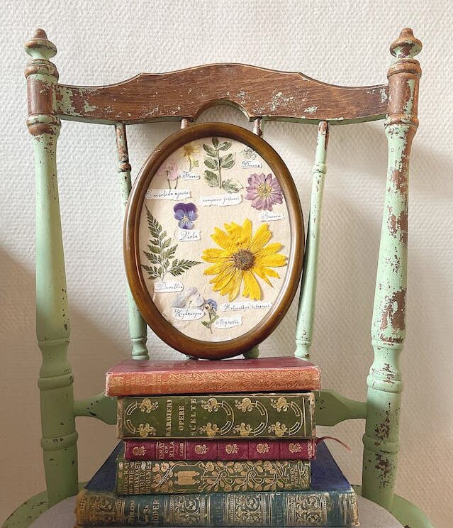 chair with books on top and framed flowers